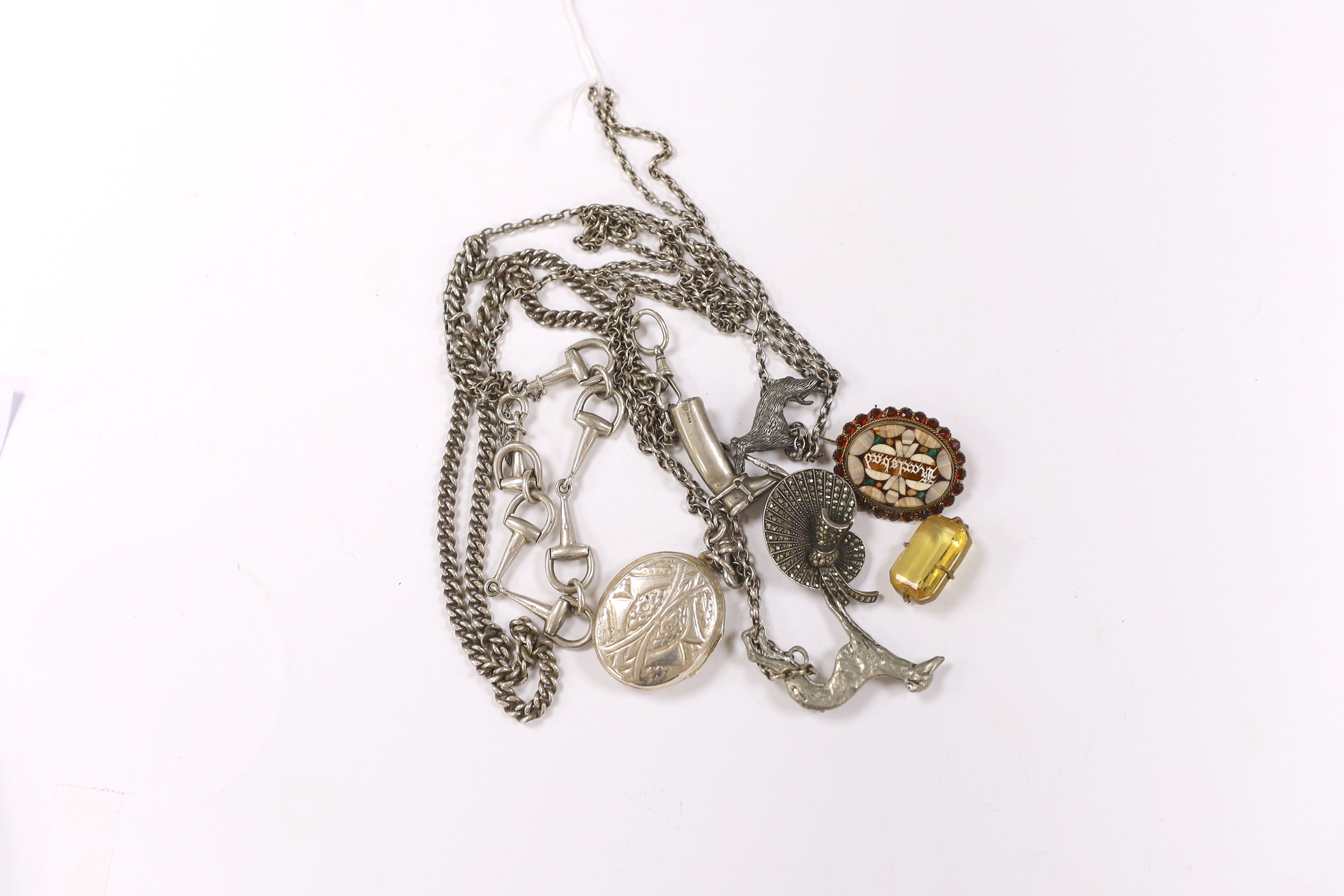 A small group of silver jewellery including a silver albert with riding boot and crop charm, a silver stirrup bracelet, a white metal locket on chain, etc.